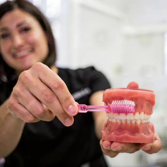 Patient maintaining healthy veneers with proper oral care